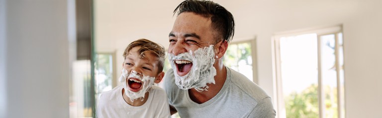 This father is avoiding being the unavailable father by spending quality time with his son and sharing a fun moment while shaving.